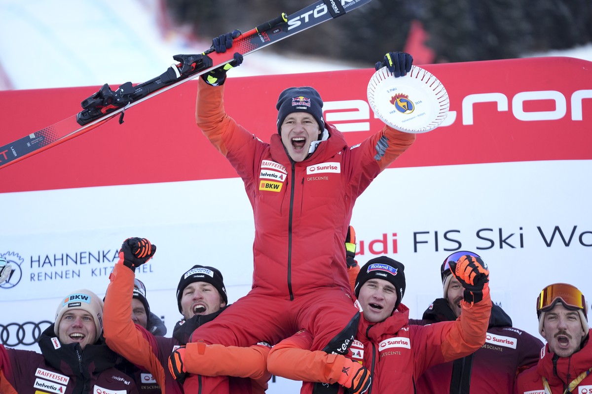 Switzerland's Marco Odermatt celebrates with the team after taking second place in an alpine ski, men's World Cup downhill race, in Kitzbuehel, Austria, Saturday, Jan. 20, 2024. (AP Photo/Gi ...