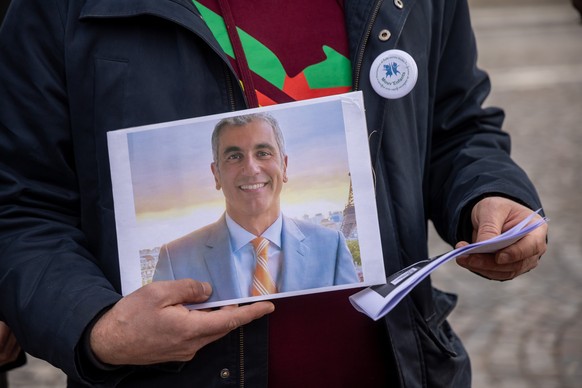 epa12761798 d Gallais founder of MouvEnfants a childrens rights association shows a poster depicting Fabrice Aidan as they demonstrate outside the Quai d'Orsay, French Ministry of Foreign Aff ...