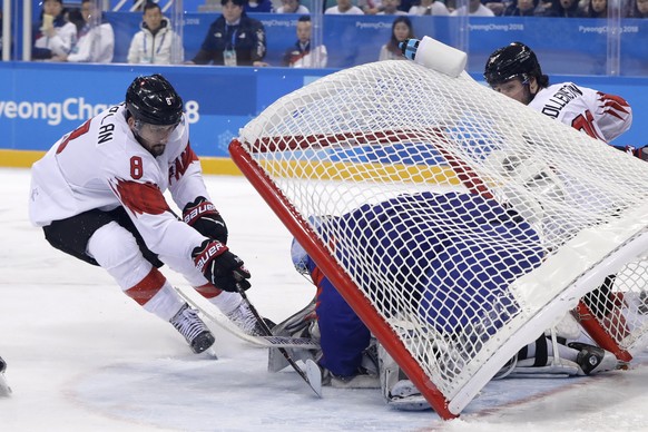 The goal falls as goalie Matt Dalton (1), of South Korea, makes a save against Vincent Praplan (8), of Switzerland, during the first period of the preliminary round of the men&#039;s hockey game at th ...
