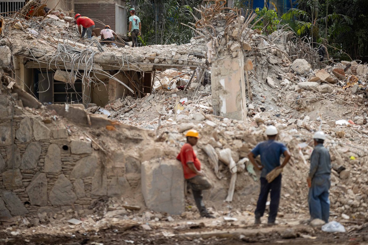 epa13101421 People clear debris from a collapsed building in Caracas, Venezuela, 09 July 2026. The official death toll from the earthquakes that struck Venezuela on 24 June rose to at least 3,811, whi ...