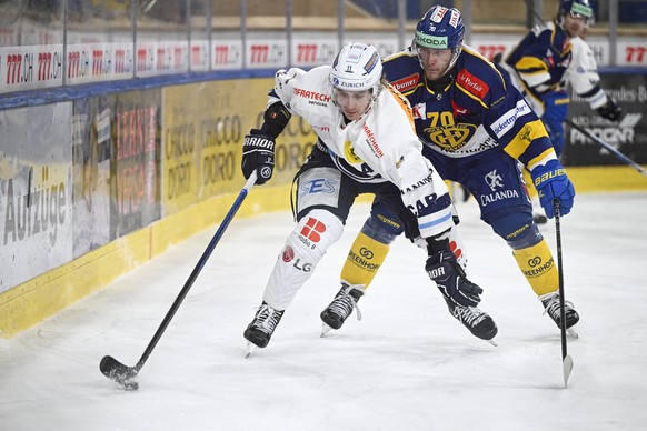 Ambri&#039;s Johnny Kneubuehler, links, gegen dn Davoser Enzo Corvi, im Eishockey-Qualifikationsspiel der National League zwischen dem HC Davos und dem HC Ambri-Piotta, am Dienstag, 19. Dezember 2023, ...