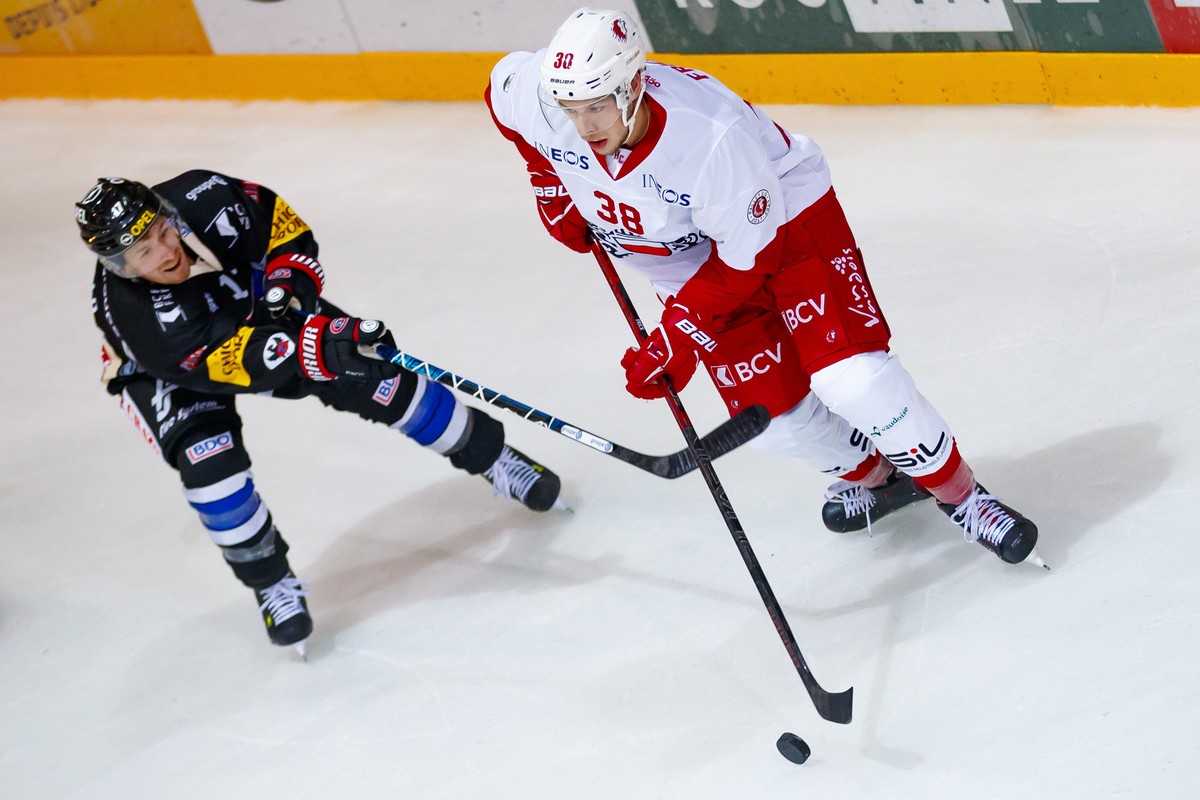 L'attaquant fribourgeois Andrew Miller, gauche, lutte pour le puck avec le defenseur lausannois Lukas Frick, droite, lors de la rencontre du championnat suisse de hockey sur glace de National Lea ...