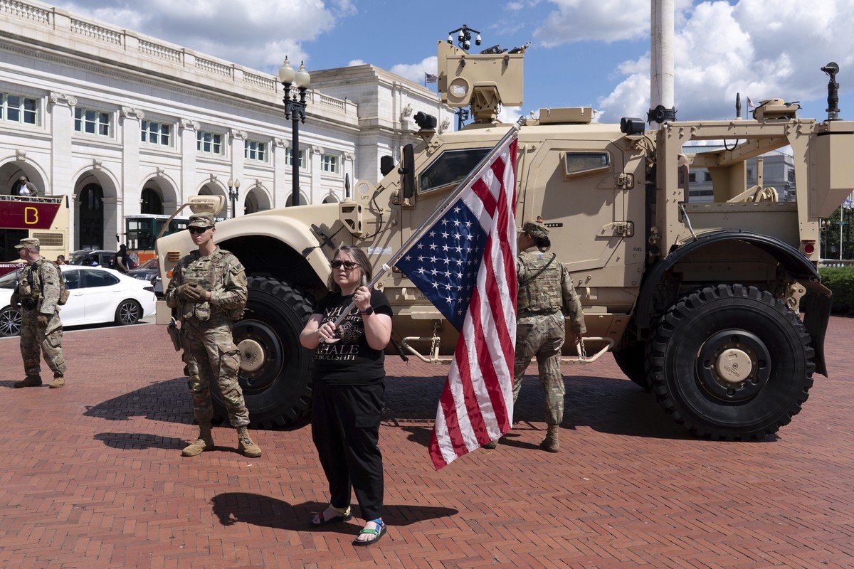 A demonstrator holds a U.S. flag as she protest against President Donald Trump's use of federal law enforcement and National Guard troops in the city during a rally at Union Station, Monday, Sept ...