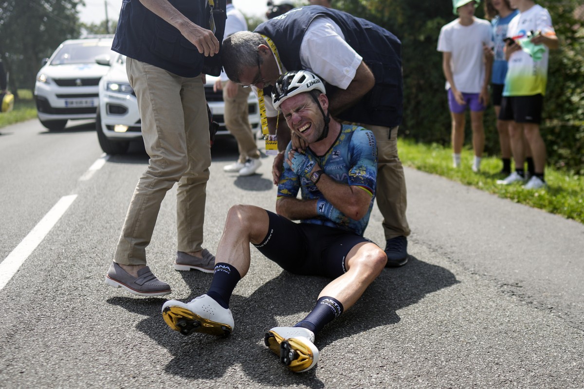 FILE - Britain's Mark Cavendish grimaces in pain as he receives medical assistance after crashing during the eighth stage of the Tour de France cycling race over 201 kilometers (125 miles) with s ...