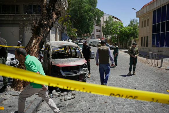 Syrisches Sicherheitspersonal sperrte die Gegend rund um das ausgebrannte Auto ab.