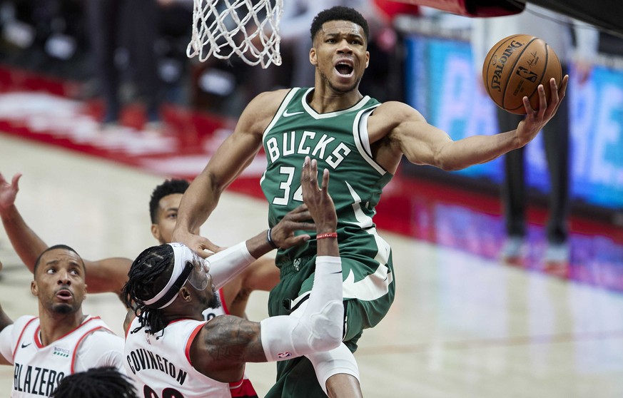 Milwaukee Bucks forward Giannis Antetokounmpo, right, shoots over Portland Trail Blazers forward Robert Covington during the second half of an NBA basketball game in Portland, Ore., Friday, April 2, 2 ...