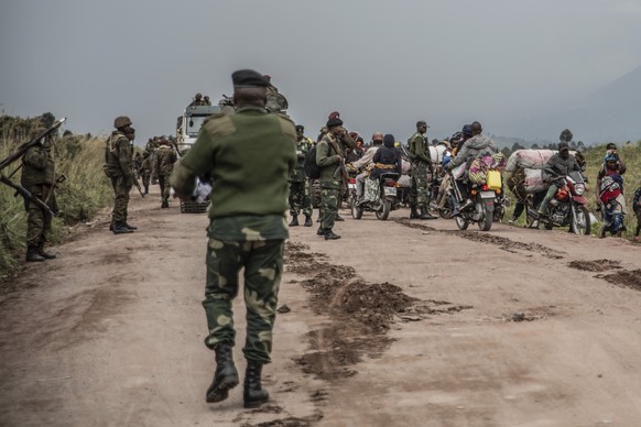People walk on the road near Kibumba, north of Goma, Democratic Republic of Congo, as they flee fighting between Congolese forces and M23 rebels in North Kivu, Tuesday May 24, 2022. Congolese authorit ...