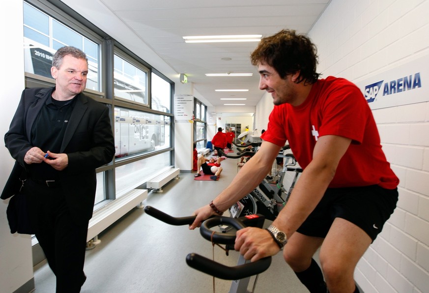 Der Schweizer Eishockey Nationalspieler Andres Ambuehl nach dem Eistraining auf dem Rad, beobachtet vom Nationaltrainer Sean Simpson, links, am Freitag, 7. Mai 2010, in der SAP Arena in Mannheim, Deut ...