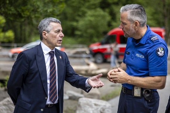 Swiss Federal Councillor Ignazio Cassis, left, speaks to William Kloter, commander of the Cantonal Police of Graubuenden, right, at the site of a landslide, caused by severe weather and heavy rain in  ...
