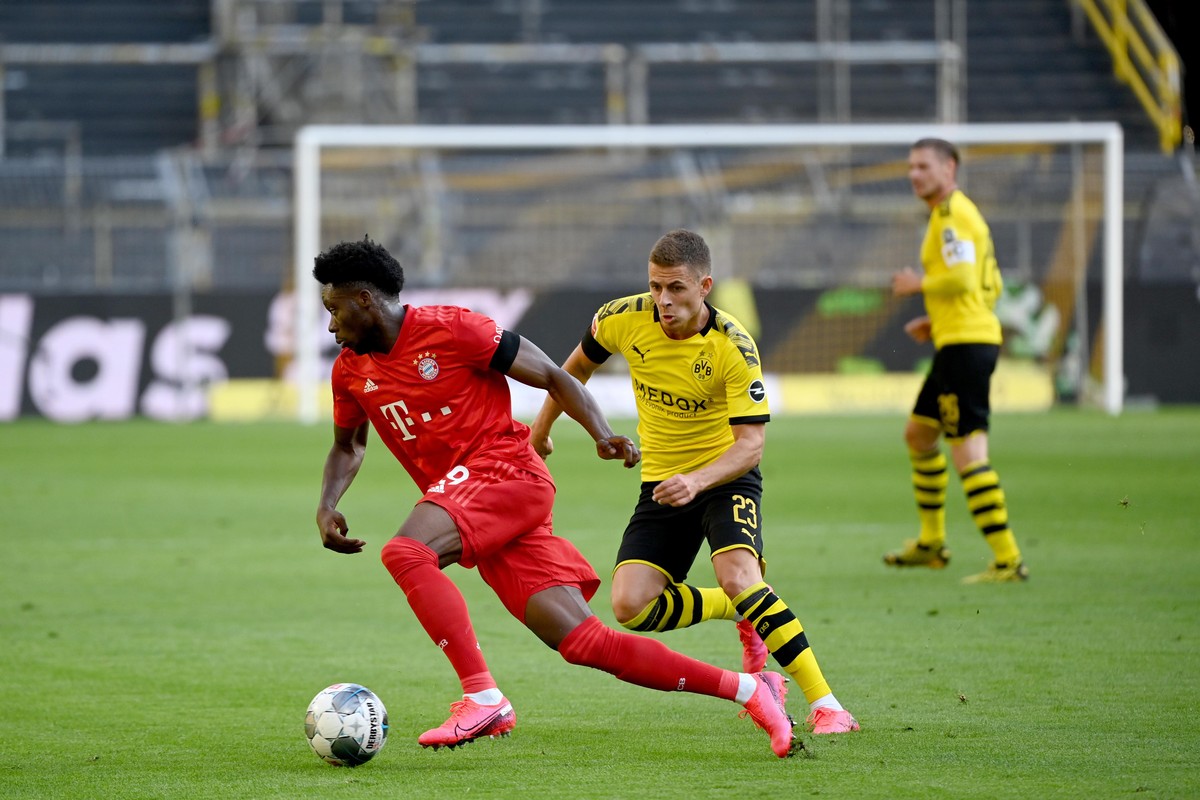 epa08445584 Bayern Munich's Alphonso Davies (L) and Dortmund's Thorgan Hazard in action during the German Bundesliga soccer match between Borussia Dortmund and FC Bayern Munich at Signal Idu ...