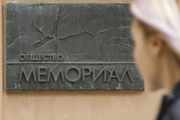 epaselect epa10229025 A woman walks past a signboard reading 'The society of Memorial' at the entrance to the head office of the Moscow Memorial Human Rights Center, in Moscow, 07 October 2022. The No ...