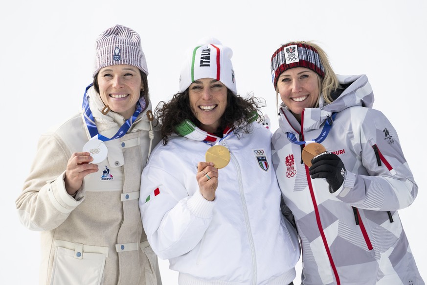 Silver medalist Romane Miradoli of France, gold medalist Federica Brignone of Italy and bronze medalist Cornelia Huetter of Austria, from left, react on the podium after the women's alpine skiing ...