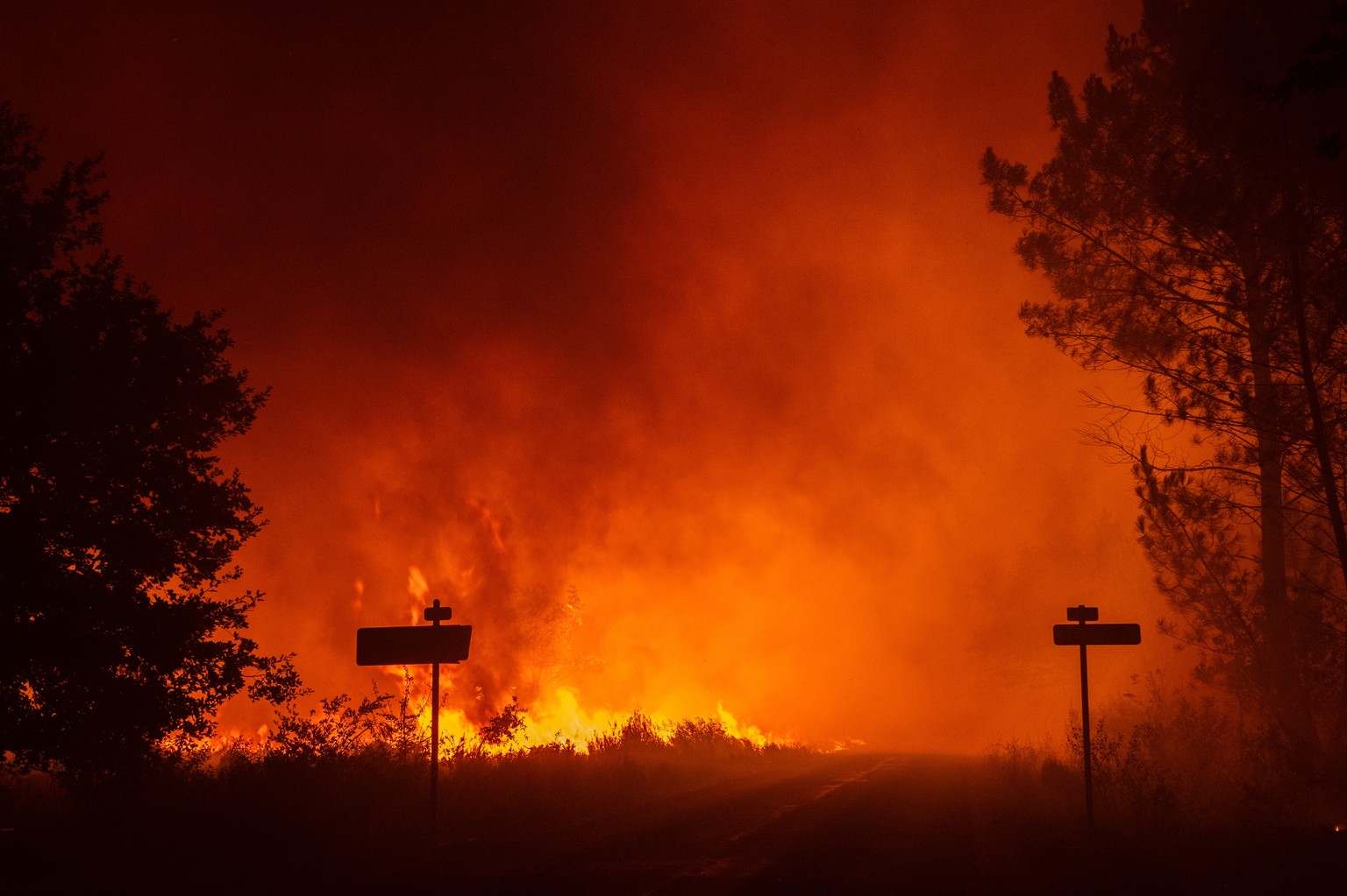 KEYPIX - epa13129763 A handout photo made available by Sdis33 (Gironde Departmental Fire and Rescue Service) shows flames engulfing a road as a wildfire spreads in Lege-Cap-Ferret, south-western Franc ...
