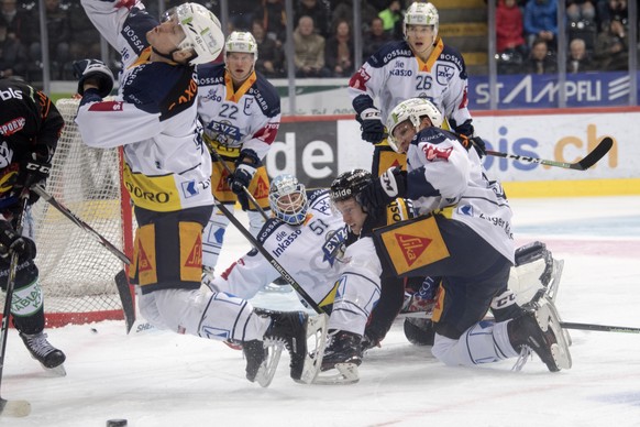 Berns Marc Kaempf, Mitte, im Duell mit Zugs Carl Klingberg, Goalie Tobias Stephan, und Timo Helbling, von links, waehrend dem Eishockey National League Spiel zwischen dem SC Bern und dem EV Zug, am Sa ...