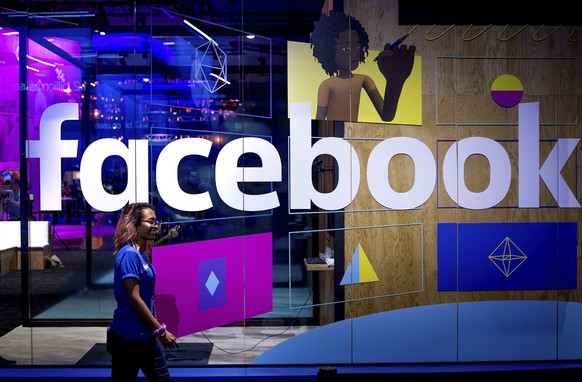 FILE - In this Tuesday, April 18, 2017, file photo, a conference worker passes a demo booth at Facebook&#039;s annual F8 developer conference, in San Jose, Calif. New York Attorney General Letitia Jam ...