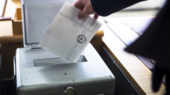 Eine Waehlerin wirft ihren Wahlzettel fuer die Erneuerungswahl der 35 zuercherischen Mitglieder des schweizerischen Nationalrates, Wahl vom 18. Oktober 2015, in die Wahlurne auf einem Kreisbuero der S ...