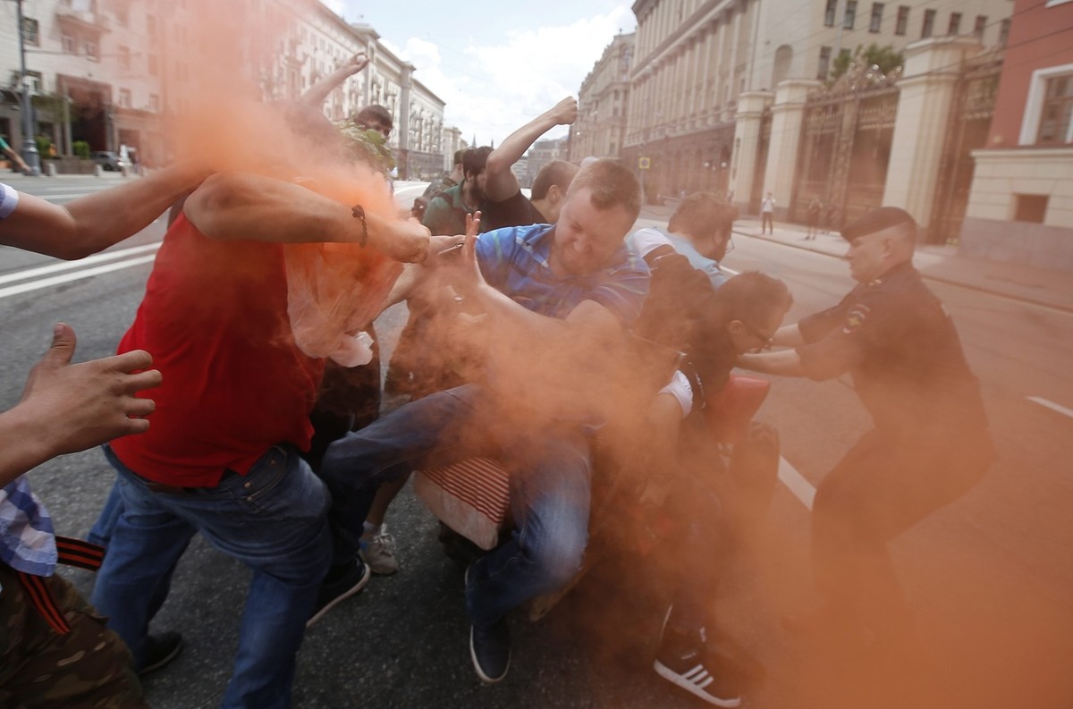epa04775275 Russian people fight with Nikolai Alexeyev (C), an activist of the LGBT (lesbian, gay, bisexual, and transgender) community, and his supporters who were trying to participate in a rally in ...
