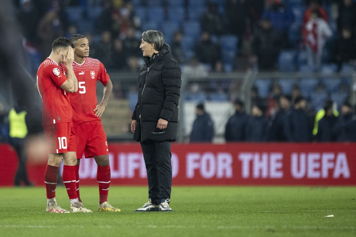 Switzerland's head coach Murat Yakin speaks with Granit Xhaka and Manuel Akanji after the UEFA Euro 2024 qualifying group I soccer match between Switzerlandat and Kosovo at the St. Jakob-Park sta ...