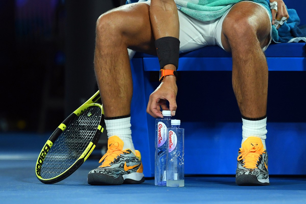 epa07308880 Rafael Nadal of Spain arranges his water bottles during a break in his men's singles quarter final match against Frances Tiafoe of the USA at the Australian Open Grand Slam tennis tou ...