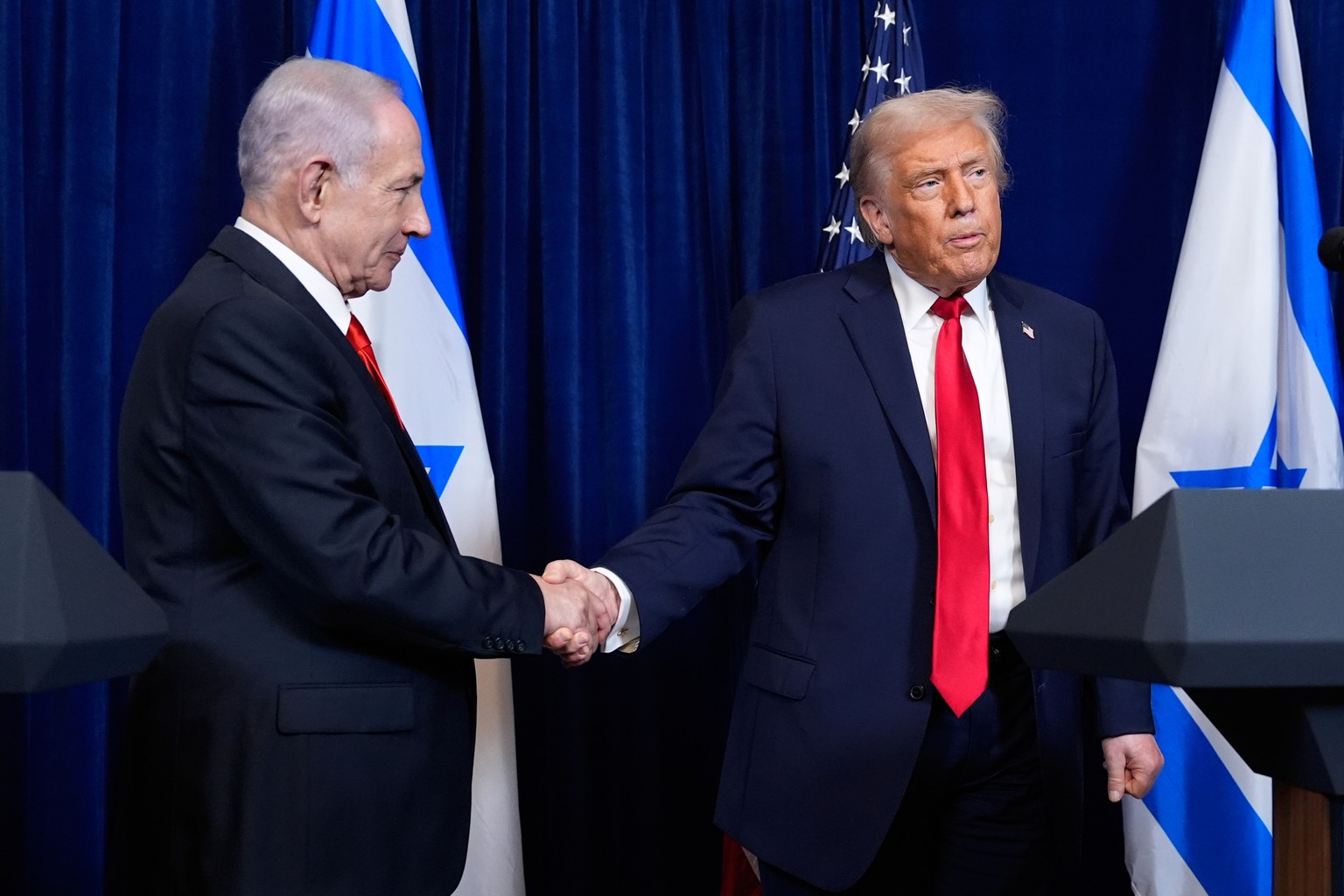 President Donald Trump shakes hands with Israel's Prime Minister Benjamin Netanyahu as he listens to a question from a reporter at the end of a news conference at Mar-a-Lago, Monday, Dec. 29, 202 ...