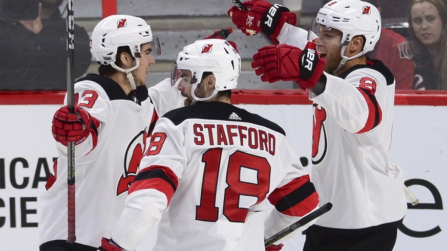 New Jersey Devils&#039; Nico Hischier, left, celebrates his goal against the Ottawa Senators with teammates Drew Stafford (18) and Taylor Hall (9) during the first period of an NHL hockey game, Thursd ...