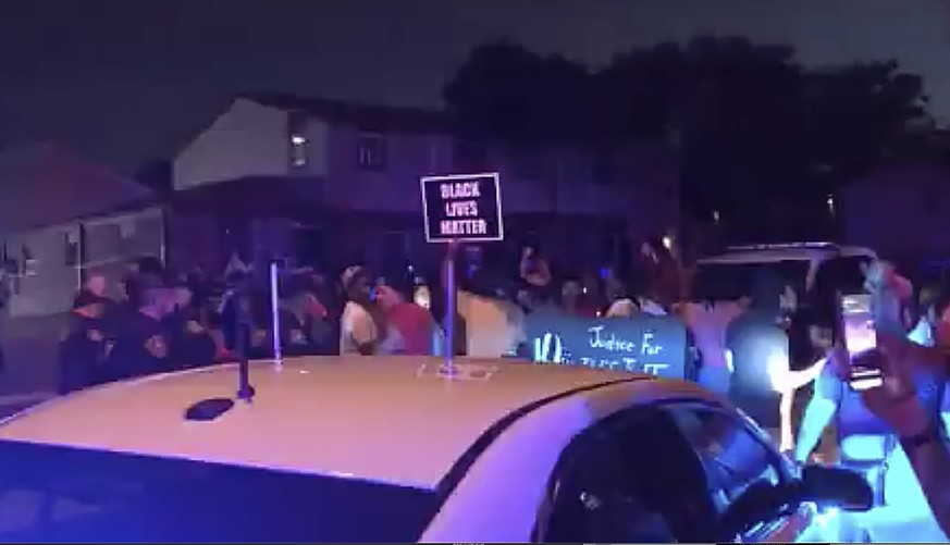 In this image made from video, protesters gather near the site of a police shooting, Sunday, Aug. 23 in Kenosha, Wisconsin. Officers deployed tear gas early Monday in an effort to disperse hundreds of ...