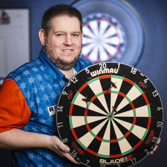 Stefan Bellmont, Dartspieler, posiert mit der Scheibe und den Pfeilen, mit welchen er sich fuer die World Darts Championships qualifiziert hat, fuer ein Portrait in seinem Dartlokal &quot;Bellis Darts ...
