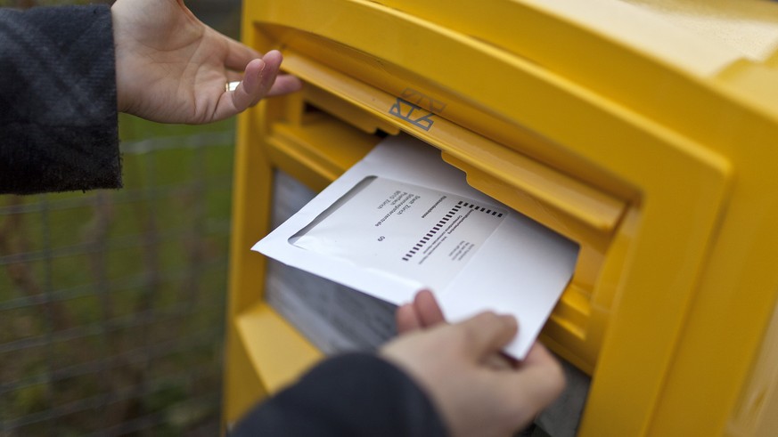 A woman drops an envelope with her vote-by-mail ballot in a letterbox on the occasion of the second tour of the election for the canton of Zurich&#039;s seat in the federal Council of States, pictured ...