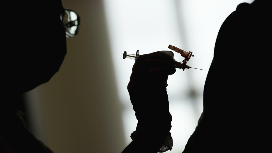 FILE - A nursing student administers the Moderna COVID-19 vaccine at a vaccination center at UNLV, in Las Vegas, April 26, 2021. The Biden administration will end most of the last remaining federal CO ...