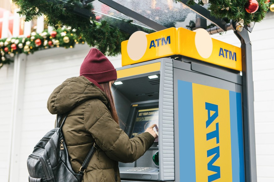 Eine junge Touristin hebt in Prag Geld vom Automaten ab: Vor dem Urlaub lohnt es sich, den Wechselkurs genauer anzuschauen.