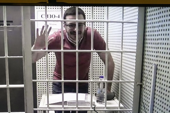 Russian opposition activist and former municipal deputy of the Krasnoselsky district Ilya Yashin is seen on a TV screen, as he appears in a video link provided by the Russian Federal Penitentiary Serv ...