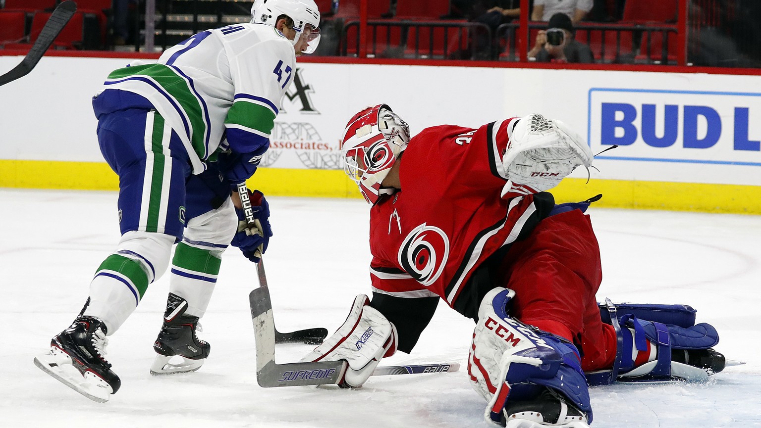 Carolina Hurricanes goaltender Curtis McElhinney (35) tries to block the shot of Vancouver Canucks&#039; Sven Baertschi (47) during the first period of an NHL hockey game, Tuesday, Oct. 9, 2018, in Ra ...