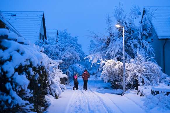 Two kids walk along a path during the season&#039;s first snow fall in Zurich, Switzerland, on Saturday, December 2, 2023. (KEYSTONE/Michael Buholzer)