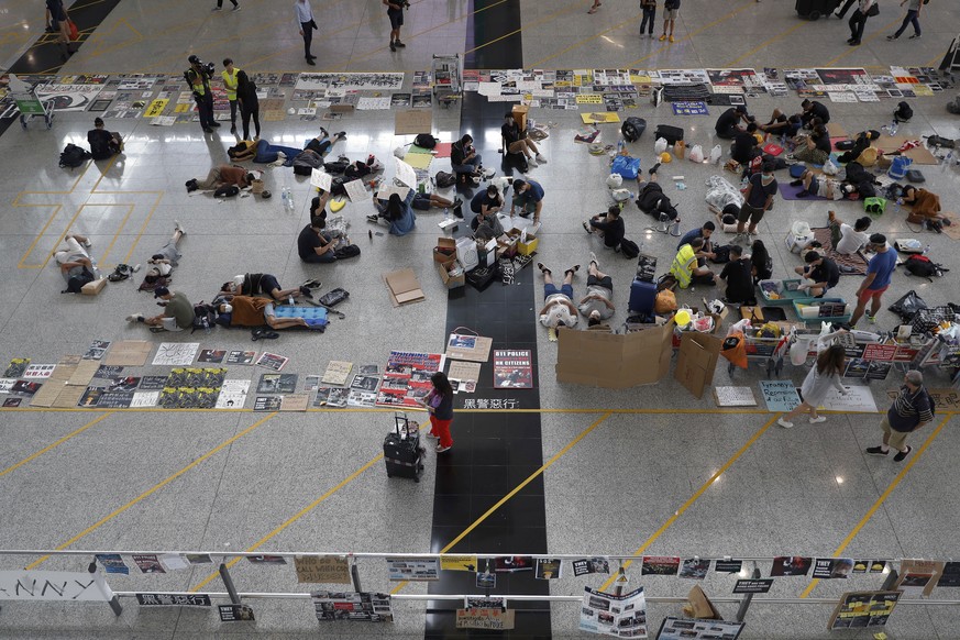 Protesters continue their sit-in rally at the airport in Hong Kong, Wednesday, Aug. 14, 2019. Flight operations resumed at the airport Wednesday morning after two days of disruptions marked by outburs ...