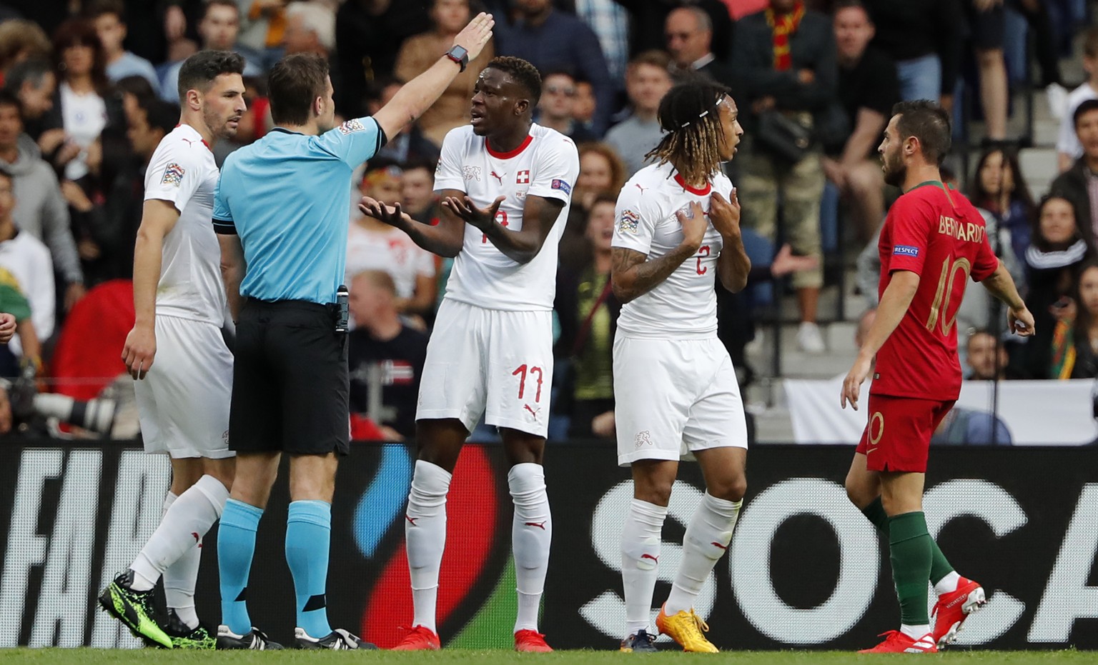 Switzerland&#039;s Renato Steffen, center, complains to Referee Felix Brych after being called for a free kick which led to the opening goal by Portugal&#039;s Cristiano Ronaldo during the UEFA Nation ...