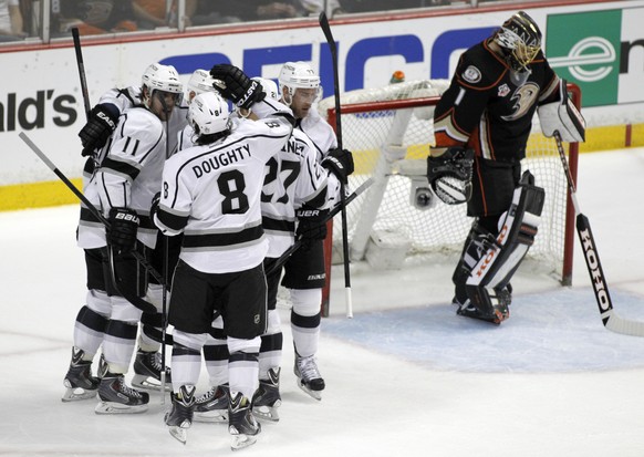 Los Angeles Kings center Anze Kopitar (11), of Slovenia, and defenseman Drew Doughty (8) celebrate defenseman Alec Martinez (27) scoring against Anaheim Ducks goalie Jonas Hiller (1), of Switzerland,  ...