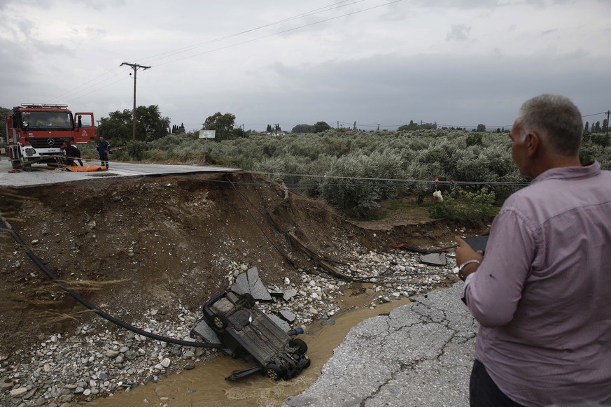 epa10844524 A car fell down a clif when a part of the road collapsed during the storm named Daniel in the area of Kala Nera at Pilio, Magnesia, Greece, 06 September 2023. At least two people died as u ...
