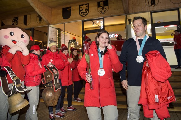 Jenny Perret, left, and Martin Rios, right, of Switzerland pose with their silver medals at the House of Switzerland after the victory ceremony of the curling mixed doubles at the XXIII Winter Olympic ...