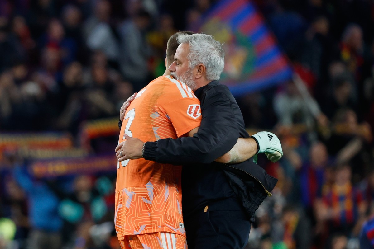 Real Madrid's head coach Jose Mourinho, right, celebrates with his goalkeeper goalkeeper Andriy Lunin at the end of the Spanish La Liga soccer match between FC Barcelona and Real Madrid in Barcel ...