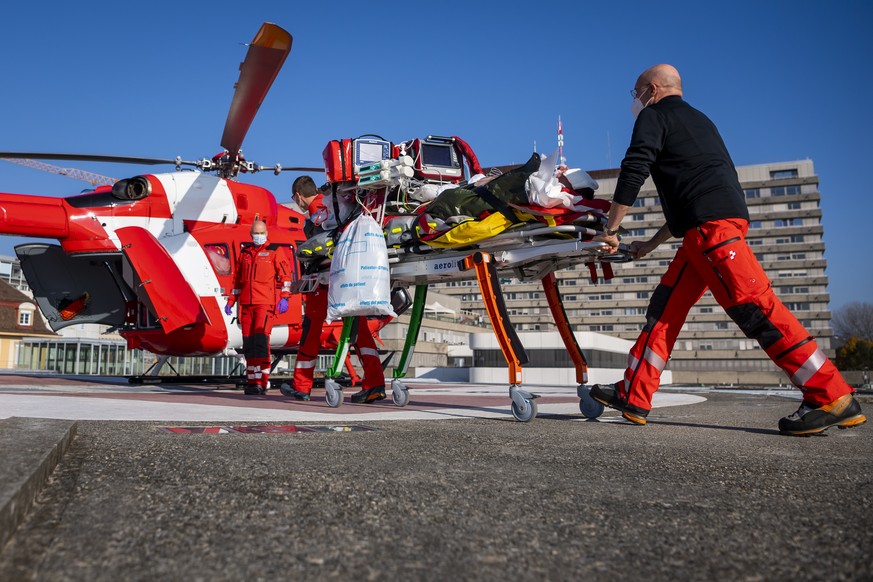 Medical staff move a patient with Covid-19 towards a Rega medical helicopter before a transfer from the intensive care unit at the the University Hospital (CHUV) to the Inselspital of Bern during the  ...