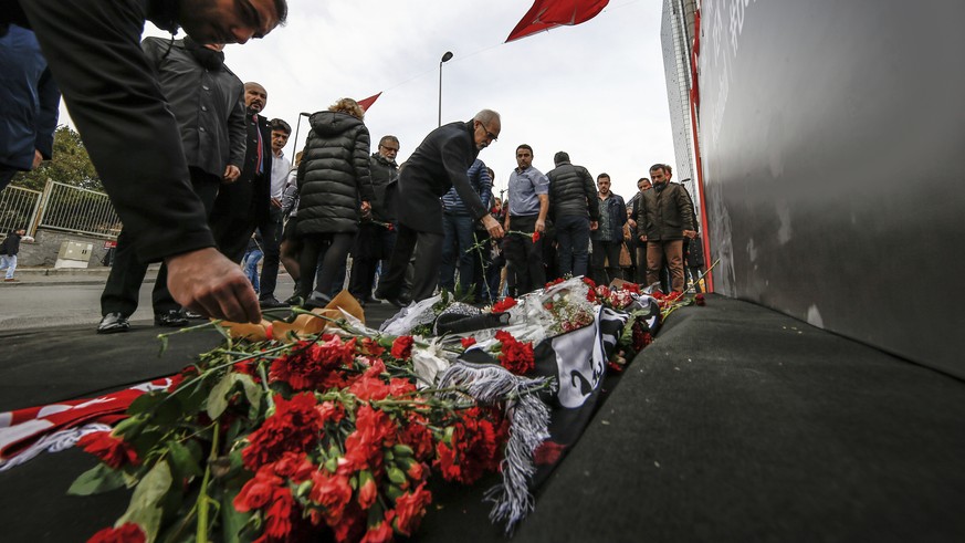 People leave carnations outside the Besiktas football club stadium Vodafone Arena in Istanbul, Monday, Dec. 12, 2016. Turkey launched a full investigation and bury the dead Monday after two bombings i ...