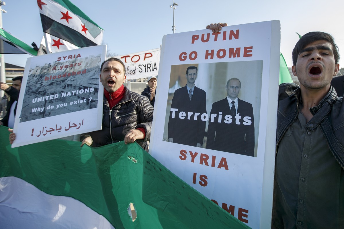 A supporter of Syrian opposition holds a picture of Bachar al Assad and Vladimir Putin with the message "Putin go Home Terrorists", during a rally for commemorate the fifth year of the war o ...