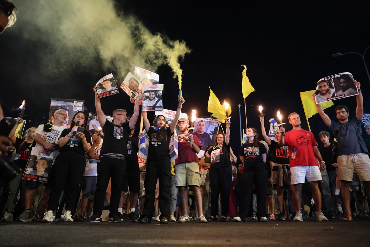 epa12288757 Families and supporters of Israeli hostages held by Hamas in Gaza carrying flares, banners and pictures of the hostages protest outside the Israeli Prime Minister's office during a se ...