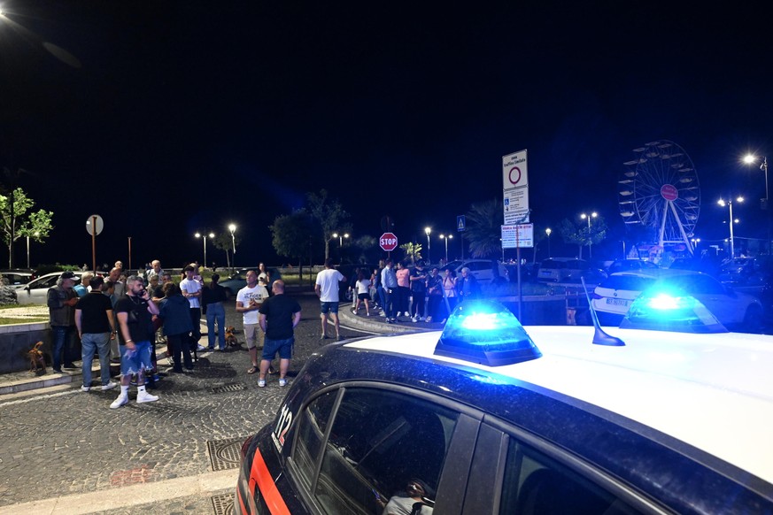 epa11356525 A police car monitors the situation as people gather in a safe area in the street on the seafront between Naples and Pozzuoli after the earthquake shocks, in Naples, southern Italy, 20 May ...