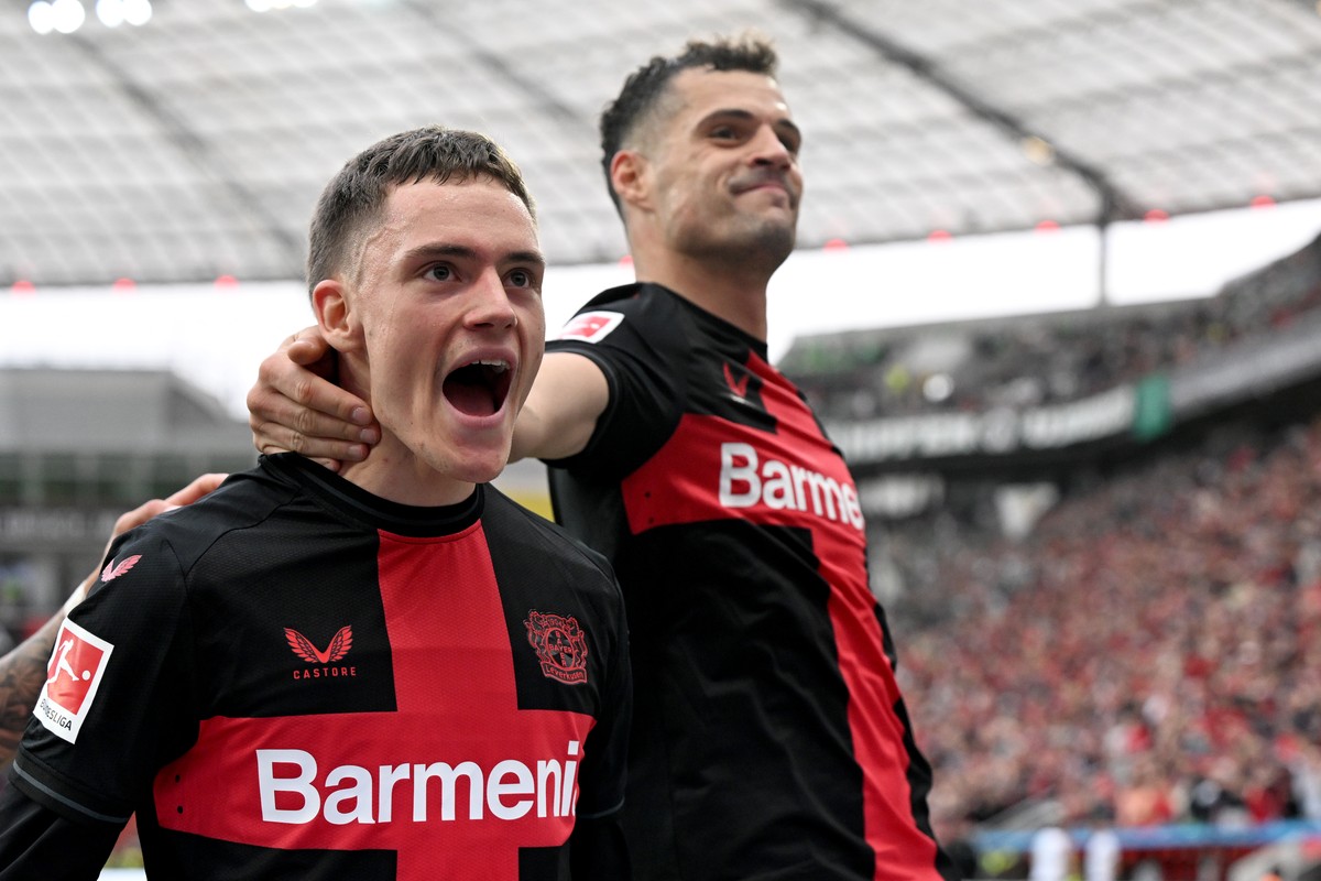14.04.2024, Nordrhein-Westfalen, Leverkusen: Fu�ball, Bundesliga, Bayer 04 Leverkusen - SV Werder Bremen, 29. Spieltag, BayArena. Leverkusens Florian Wirtz (l) bejubelt sein Tor zum 3:0 mit Granit Xha ...