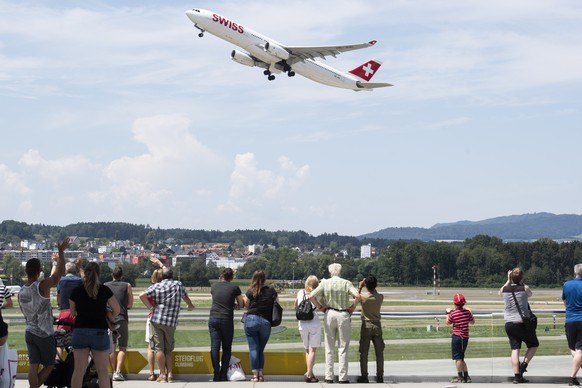 Zuschauer verfolgen den Start eines Flugzeugs auf dem Flughafen in Zuerich, aufgenommen am Sonntag, 15. Juli 2018. (KEYSTONE/Ennio Leanza)