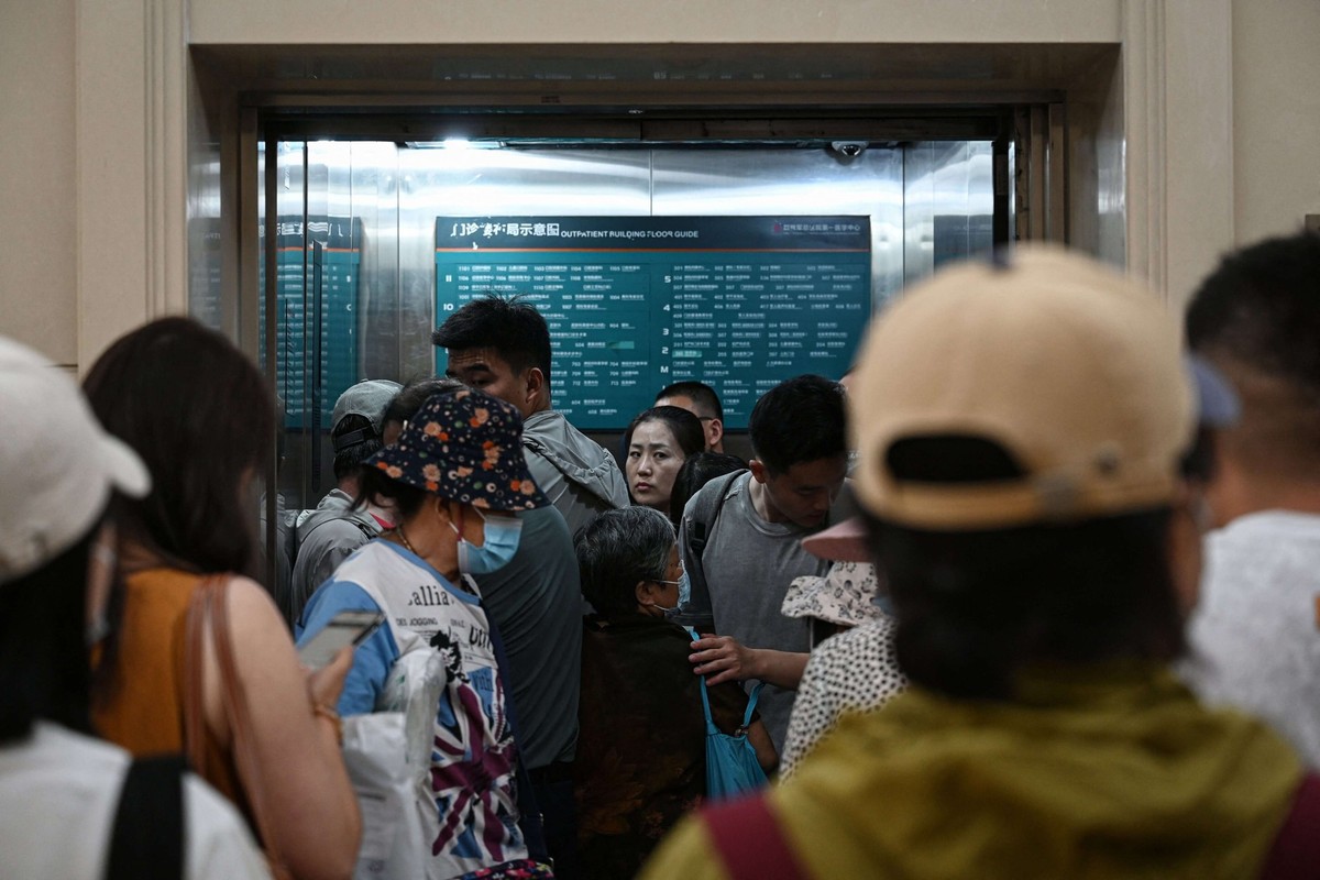 Cette photo prise le 23 juin 2025 montre des personnes attendant de prendre un ascenseur bondé dans un hôpital de Pékin.