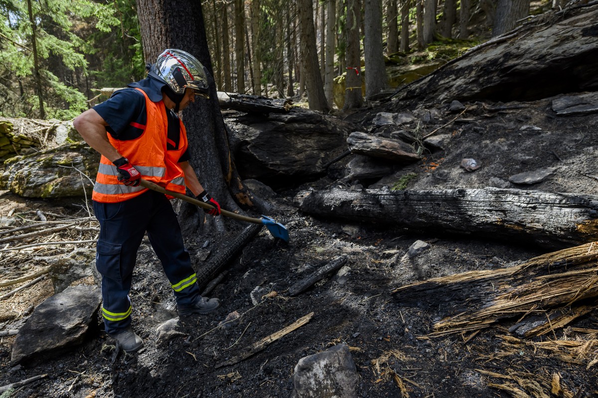 Des pompiers continuent d'eteindre le feu de l'incendie de foret au-dessus de Bitsch/Ried-Moerel le vendredi 28 juillet 2023 a Bitsch dans le Haut-Valais. (KEYSTONE/Jean-Christophe Bott)