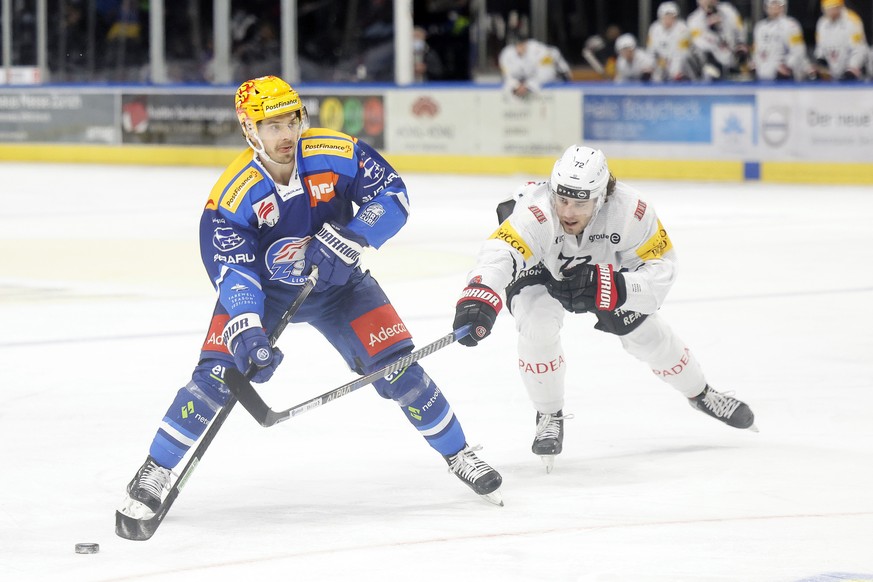 Der PostFinance Top Scorer Denis Malgin, links, gegen Gotterons Gaetan Jobin im Eishockeyspiel der National League zwischen den ZSC Lions und dem HC Fribourg Gotteron am Sonntag, 2. Januar 2022 im Zue ...