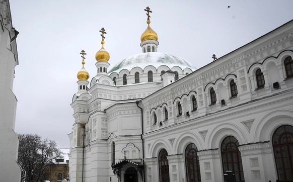 A woman cleans the snow at the Pechersk Lavra monastery complex in Kiev, Ukraine, Tuesday, November 22, 2022. Ukraine's Counterintelligence Service, police officers and the country's National Guard are searching…